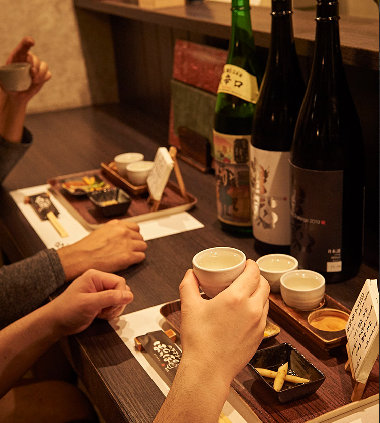 カウンターで酒器を持つ手元 